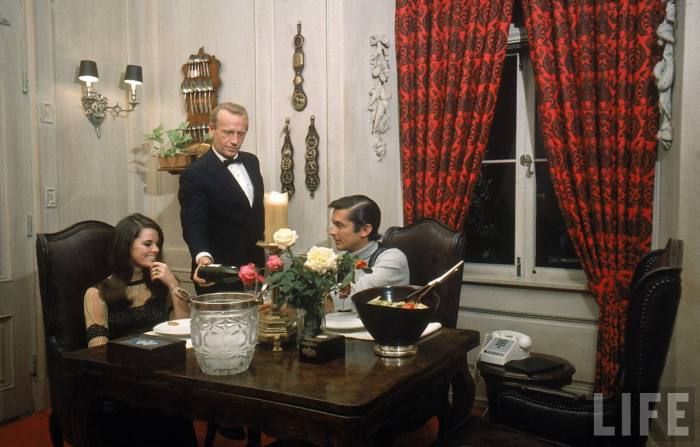 Film director Robert Evans and girlfriend Libby Boehmer being served dinner by butler at his home-- Beverly Hills, 1968.