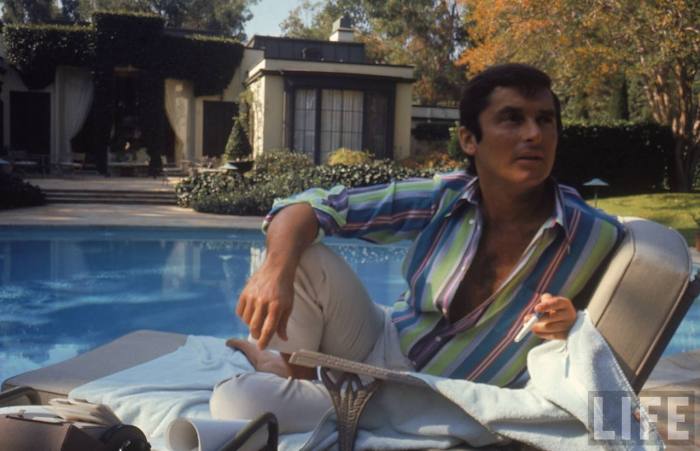 VP of Paramount Pictures Robert Evans studying his script by the pool at his home-- Beverly Hills, CA 1968.